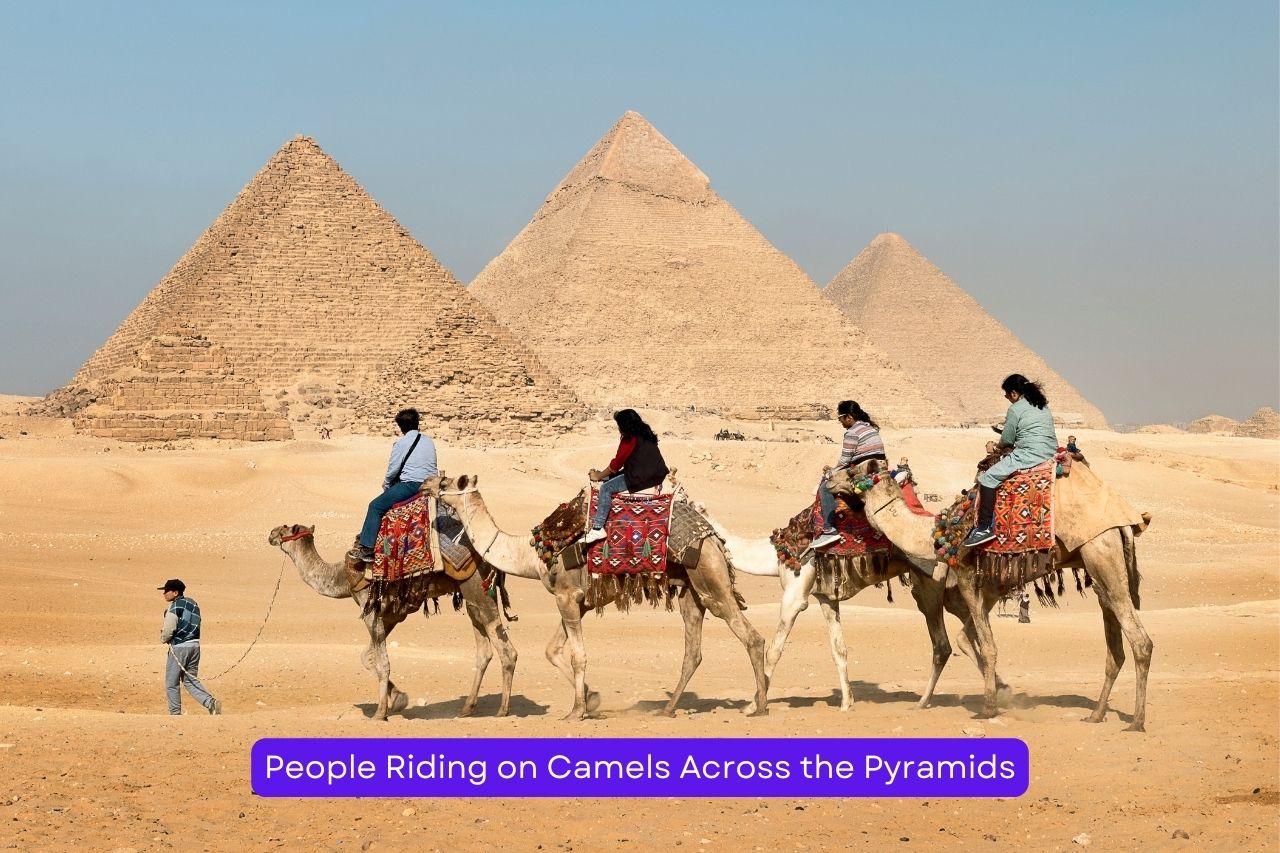 People Riding on Camels Across the Pyramids